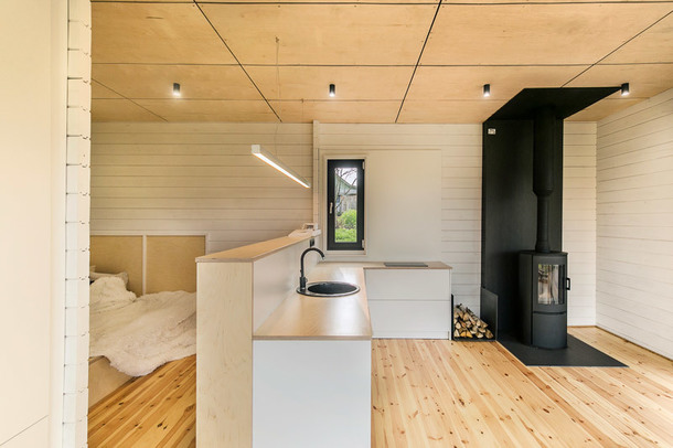 З фанери також зроблена кухня, нею ж оброблений низ стіни в зоні спальні, щоб візуально виділити цей простір