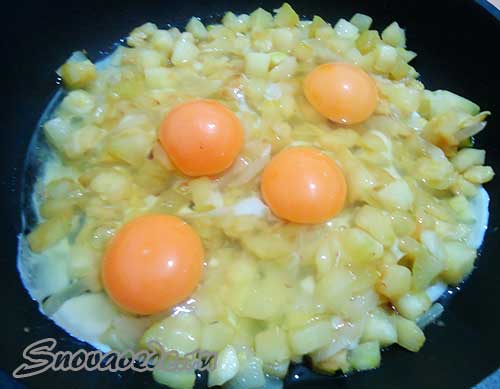 Коли побачите, що кабачки готові, в сковорідку розбити яйця, посолити і перемішати, обсмажувати до повної готовності яєць