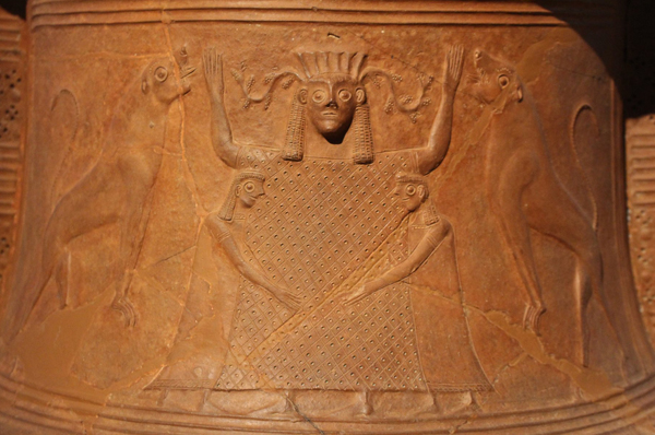 Голову богині Реї (Кібели) прикрашала висока корона з зубцями, в руках вона тримає бубон, ударний музичний інструмент з певною висотою звучання і скіпетр або колосся